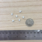 1:12 scale miniature metal round cabinet knobs in white, set of 6, shown on a wood surface with a coin and a ruler