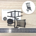 1:12 scale miniature fan back Windsor chair kit in black, unassembled parts on sprues, shown with a coin and a ruler