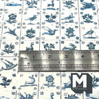 1:12 scale miniature early Delft tile wallpaper in blue and white with birds, animals and flowers, shown with a ruler