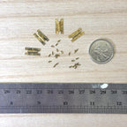 1:12 scale miniature brass H hinges with screws, set of 4, shown on a wood surface beside a coin and a ruler