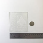1:12 scale miniature clear stained glass window insert with diamond and flower design, shown with a coin and a ruler