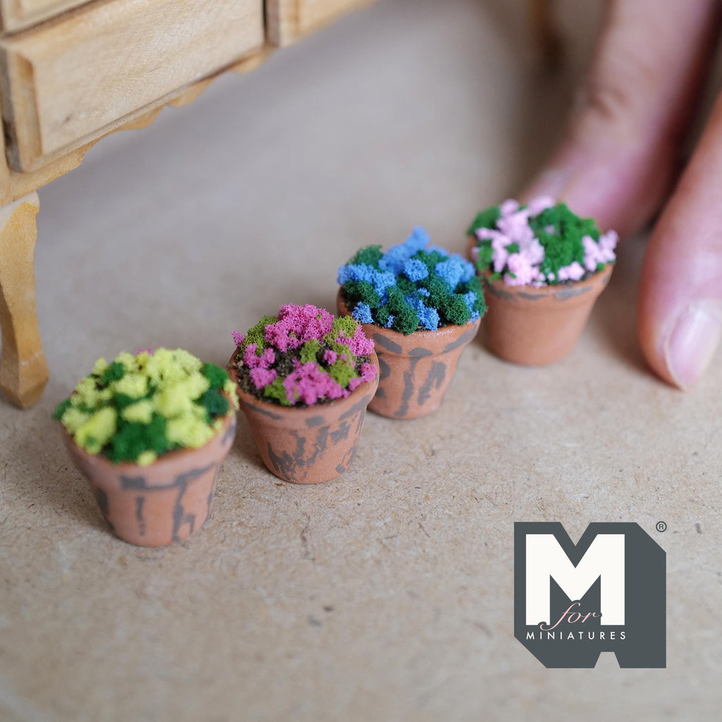 1:12 scale miniature weathered terracotta pots with magenta, blue, light pink and yellow textured flowers over green foliage