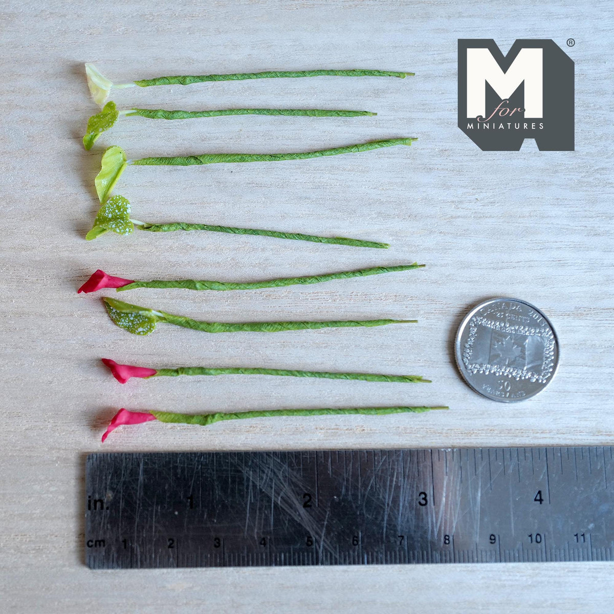 1:12 scale miniature red calla lily flower stems with pale yellow centers and lime green leaves with white speckles, on green wrapped stems
