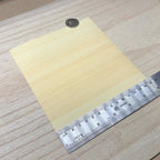 Hinoki cypress wood veneer sheet shown next to a ruler for scale, 5-7/8 inch square and 0.15 mm thick