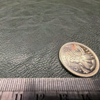 Close view of the pebbled grain on the dark green faux leather sheet