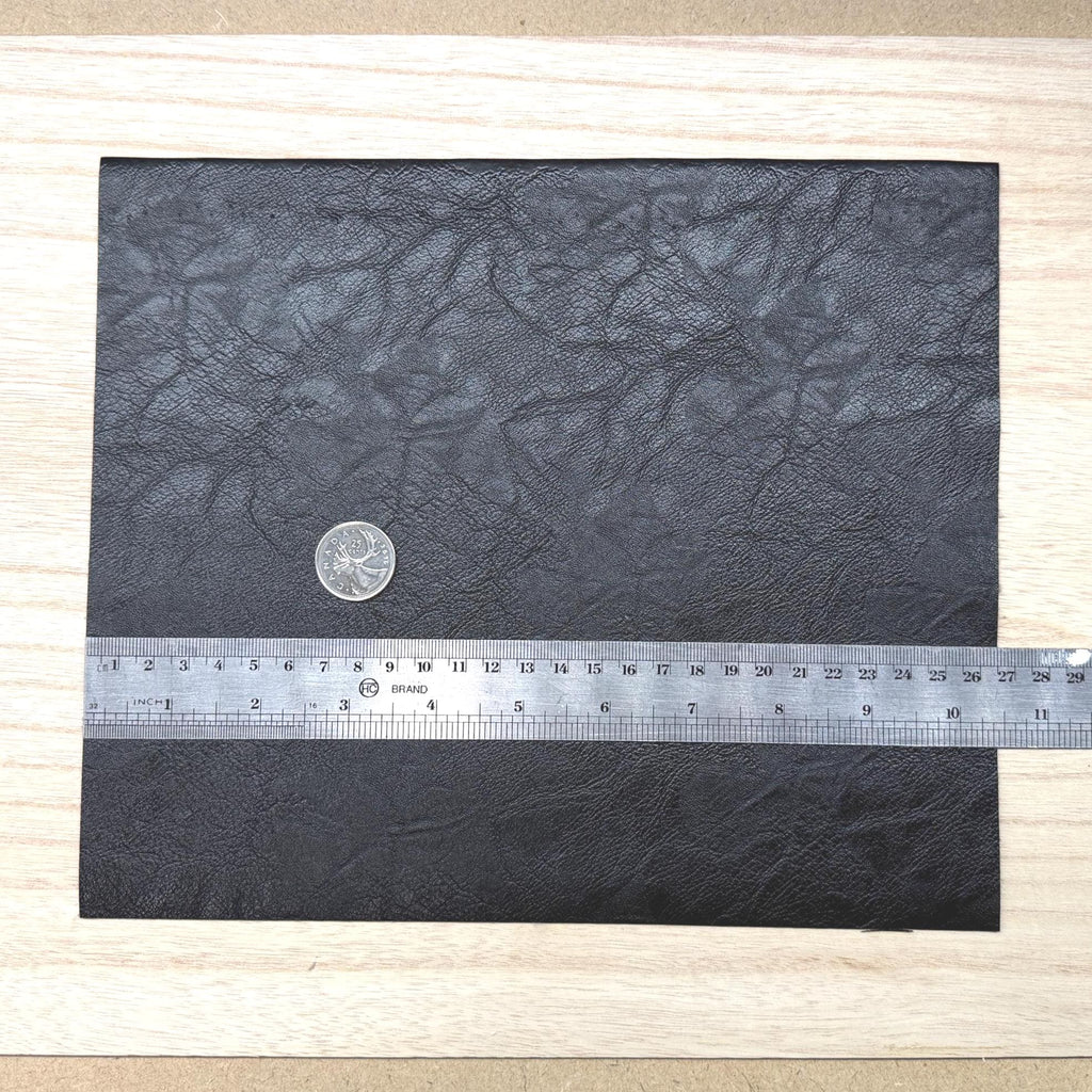 Black faux leather sheet with soft pebbled grain and a low-sheen matte surface, 10-7/16 x 8-7/8 inch