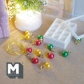 1:12 scale miniature Christmas ornaments in red, green and gold with gold-tone caps, in a white 12 compartment storage box with a clear lid