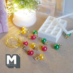 1:12 scale miniature Christmas ornaments in red, green and gold with gold-tone caps, in a white 12 compartment storage box with a clear lid