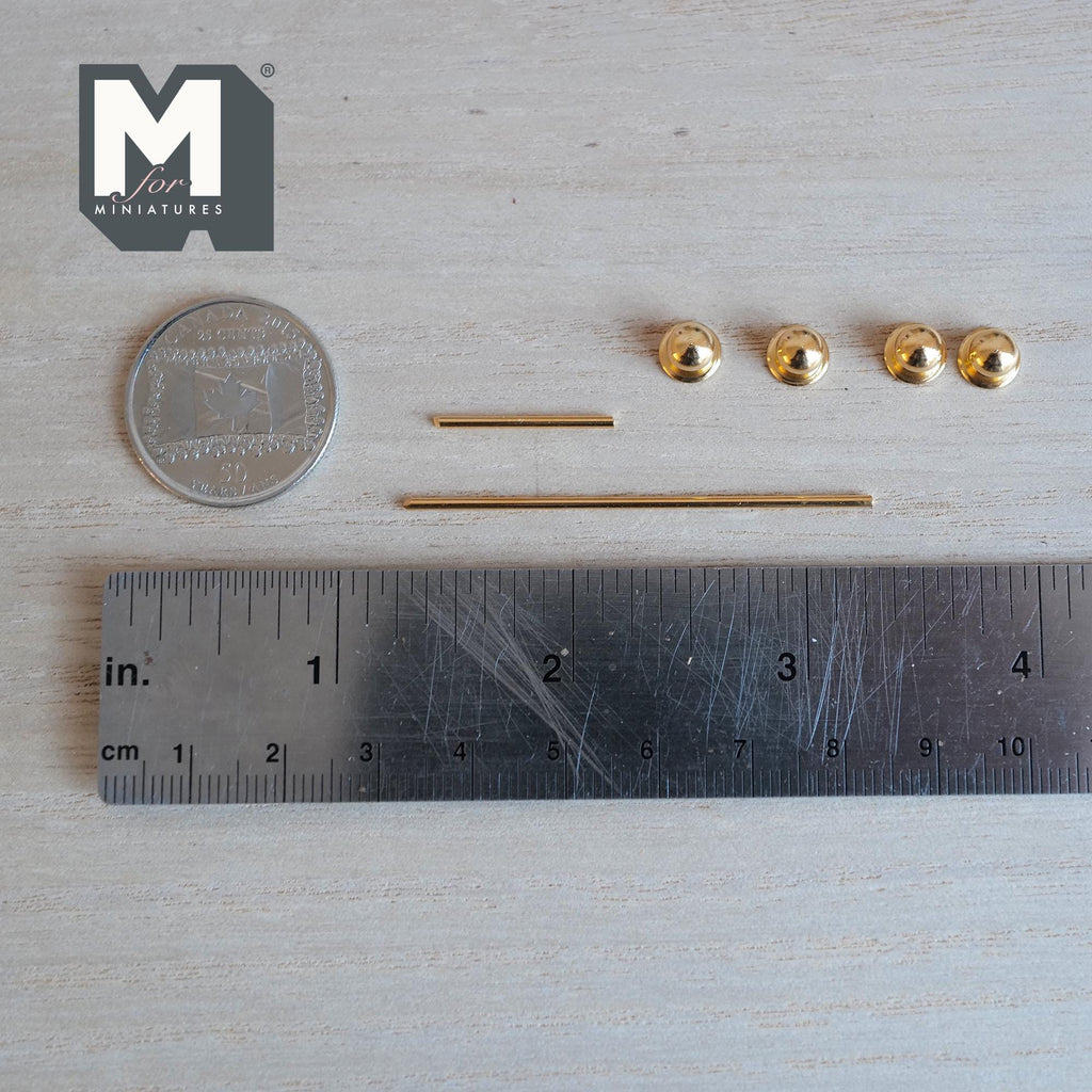 Unassembled 1:12 scale miniature gold towel bar and toilet paper holder set: four round end knobs with backplates and two gold rods laid beside a ruler and coin