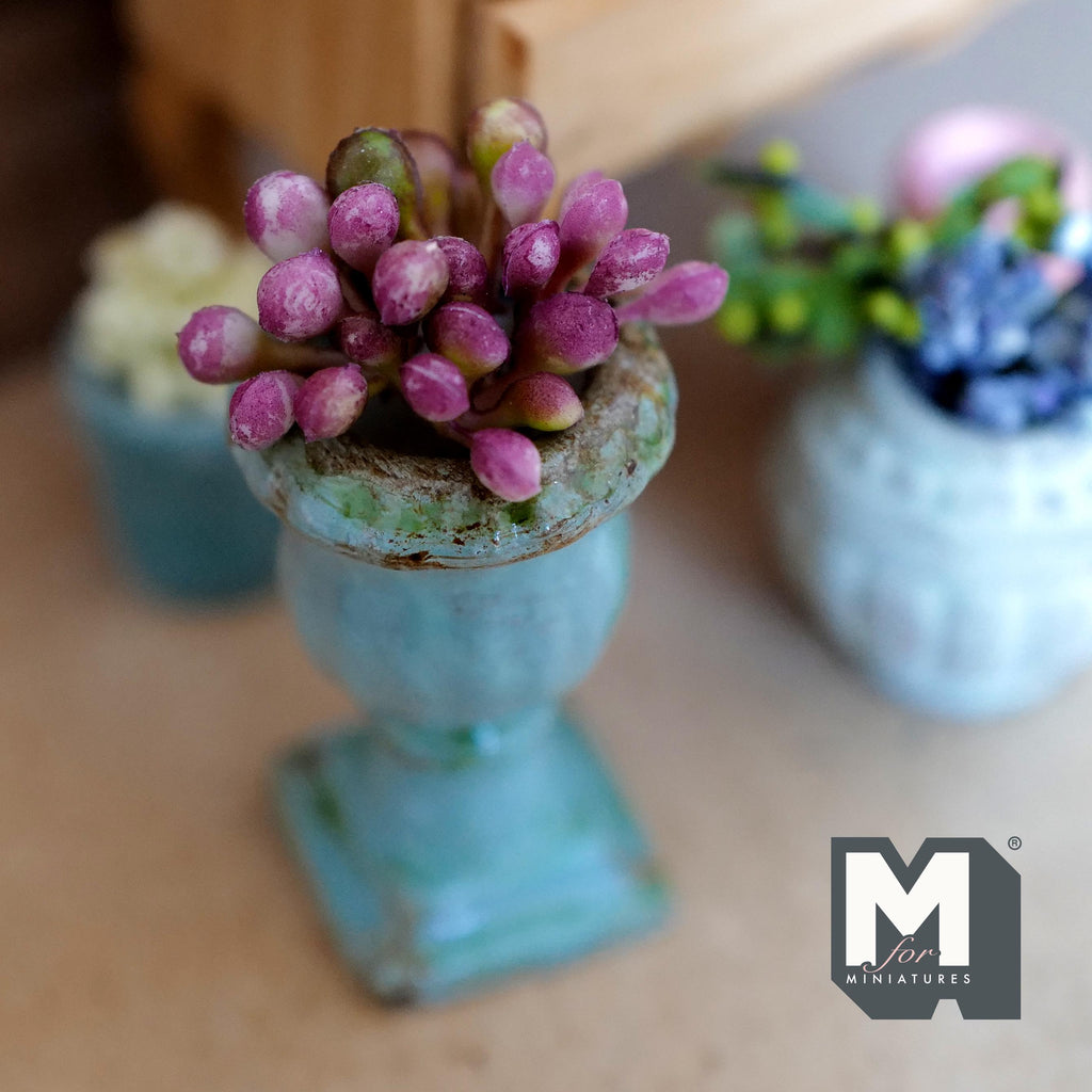 1:12 scale miniature weathered teal ceramic Roman style pedestal urn on a square base, planted with pink and purple flower buds