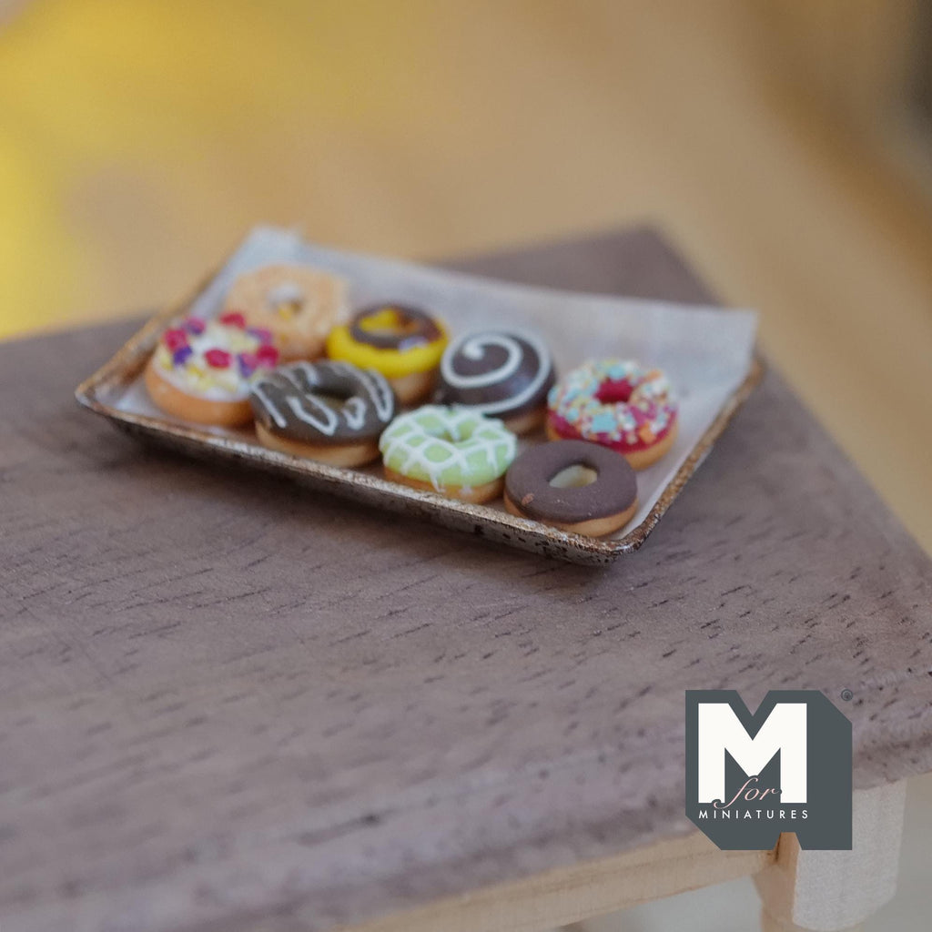 Donuts glacés miniatures sur plaque de cuisson en métal vieilli avec papier sulfurisé à l'échelle 1:12, lot de 9, 1-5/8 pouce de long, décoration pour maison de poupée