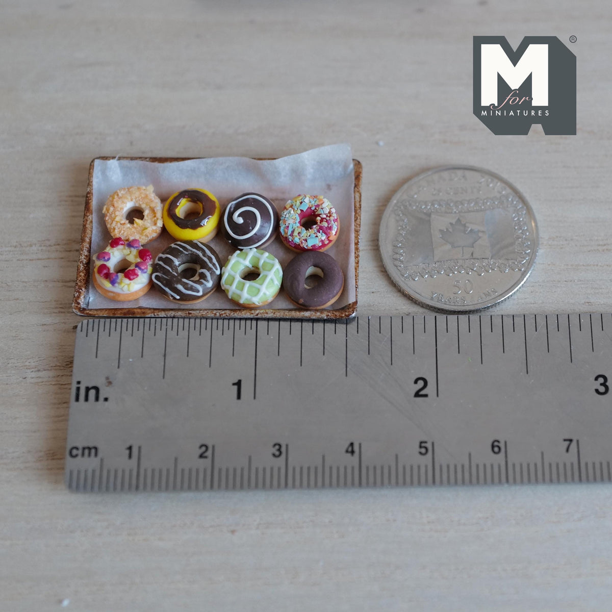 Donuts glacés miniatures sur plaque de cuisson en métal vieilli avec papier sulfurisé à l'échelle 1:12, lot de 9, 1-5/8 pouce de long, décoration pour maison de poupée