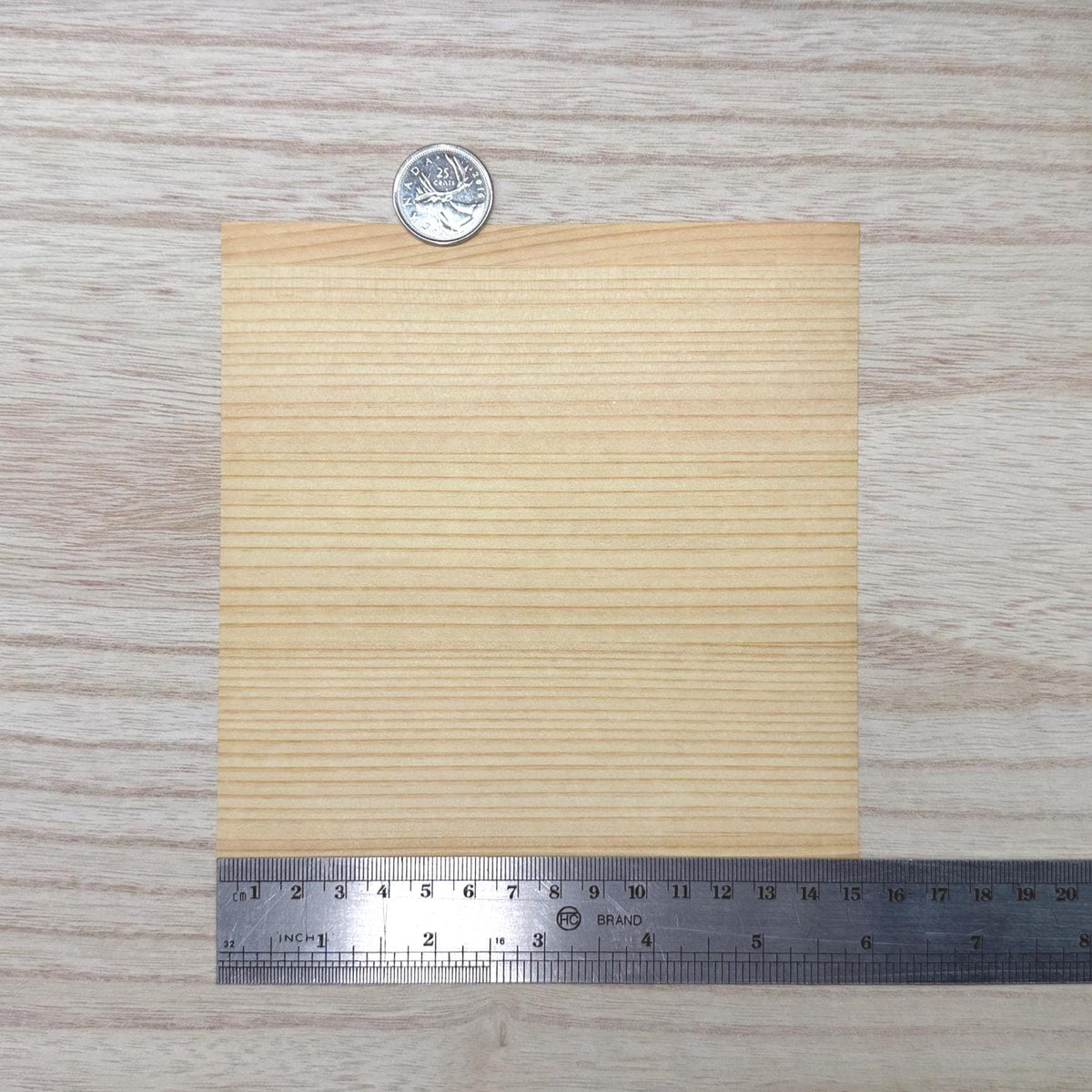 Miniature Douglas fir wood veneer sheet in warm honey amber with straight tightly spaced grain, 5-7/8 inch square