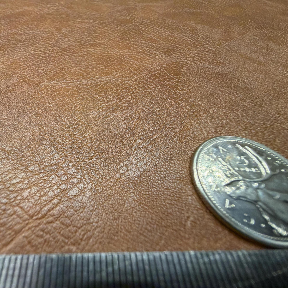 Close view of the pebbled grain on the brown faux leather sheet