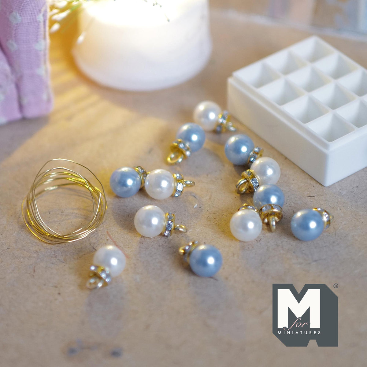 1:12 scale miniature Christmas ornaments in light blue and pearl white with gold-tone caps, in a white 12 compartment storage box with a clear lid