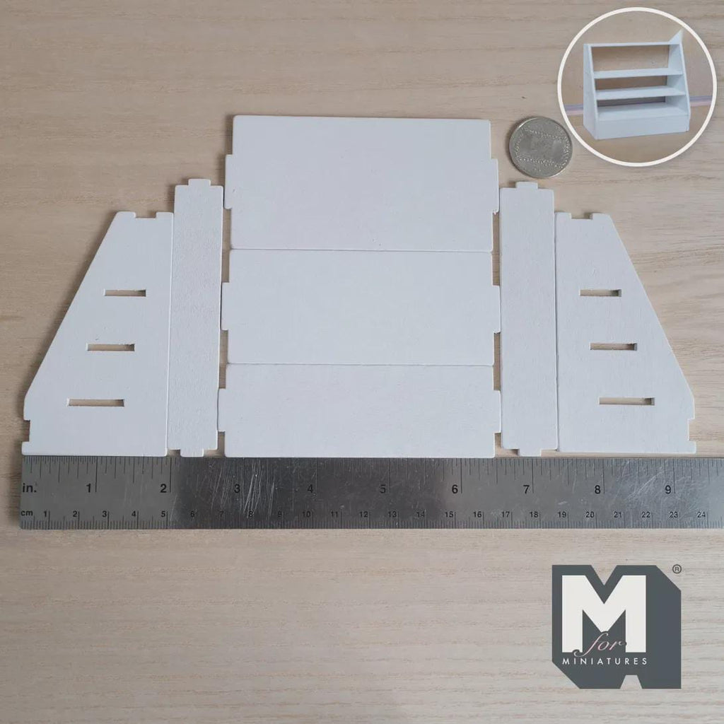 Unassembled 1:12 scale miniature 4 tier stepped display shelf kit in white wood, laid flat beside a ruler and coin, with an inset of the assembled shelf