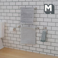 1:12 scale miniature silver towel bars, towel ring and toilet paper holder on a white subway tile wall, hung with gray patterned towels, a green and white striped hand towel and a paper roll