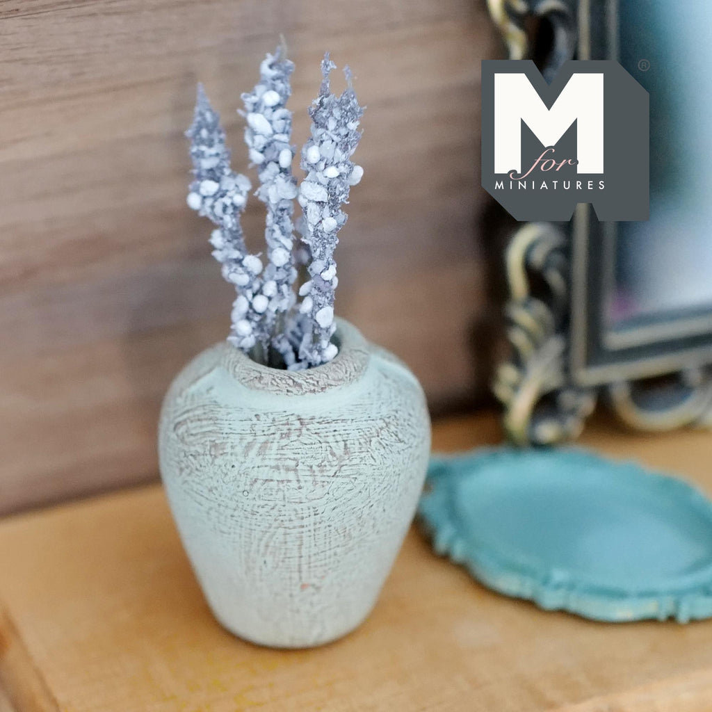 1:12 scale miniature weathered mint green clay plum shaped vase with a short neck, holding a bunch of sparkly silver flower stems