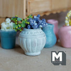 1:12 scale miniature weathered gray clay urn pot with fluted sides, planted with blue flowers and green leaves
