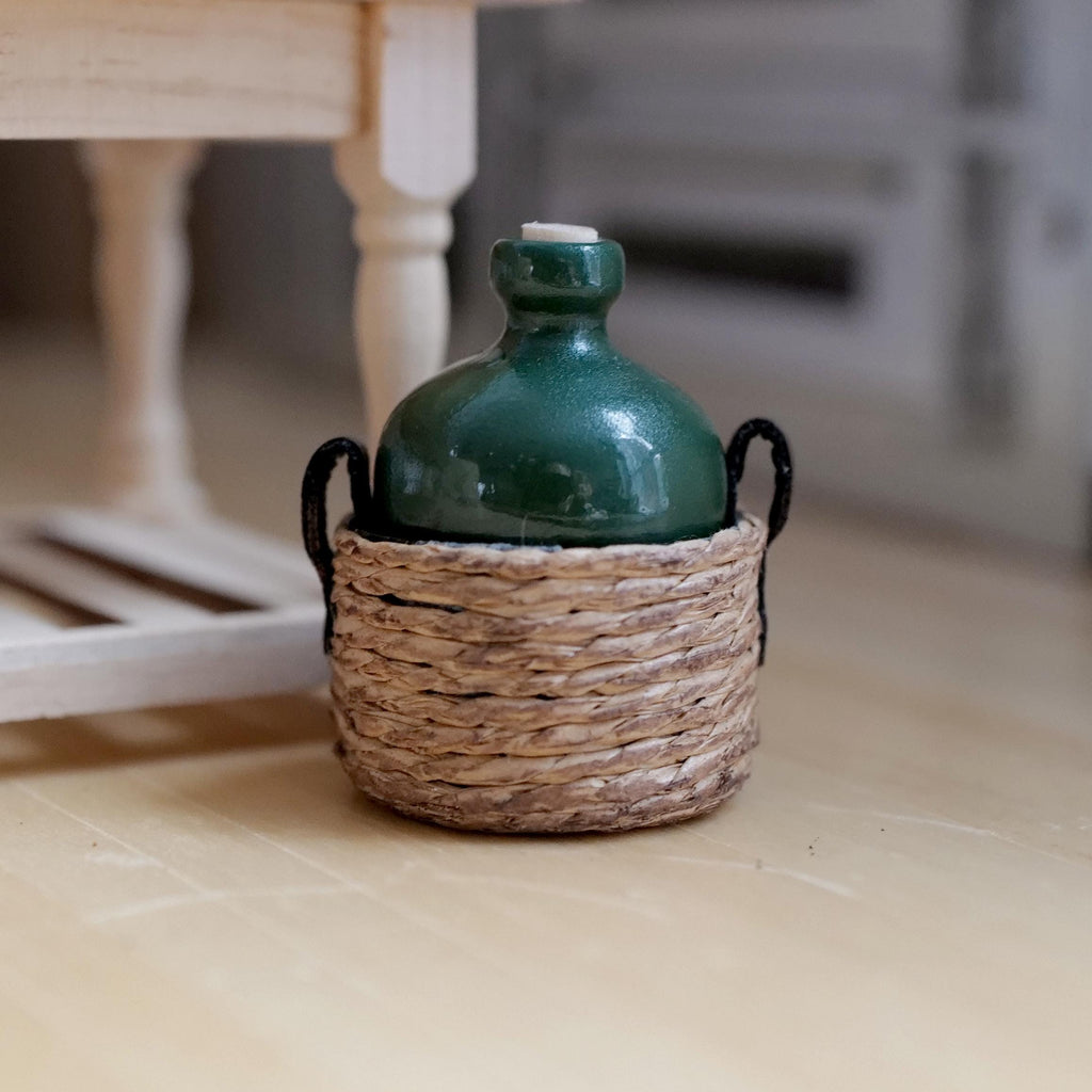 1:12 scale miniature dark green carboy jug with cork stopper in a woven rope basket with faux leather handles