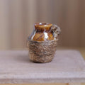 1:12 scale miniature brown glazed ceramic jug wrapped in jute twine on a wood table